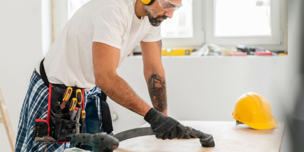 Home DIY, Mature man vacuuming dust on a table